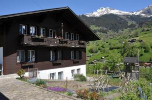 une maison avec un balcon donnant sur la montagne en arrière-plan dans l'établissement Ferienwohnung im Chalet Adelheid, à Grindelwald