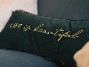 a black pillow with the words life of beautiful written on it at Superbe T2 avec vue sur cour - Rouen centre in Rouen