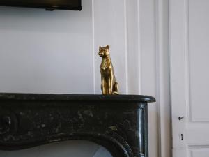 a gold cat statue sitting on top of a fireplace at Superbe T2 avec vue sur cour - Rouen centre in Rouen