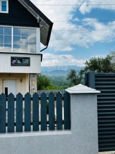 a fence in front of a house with mountains in the background at Prater House Mountain View in Moieciu de Jos