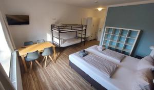 Habitación con 2 camas, mesa y sillas en Ording Beach Hotel en Sankt Peter-Ording
