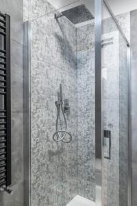 a shower with a glass door in a bathroom at PETIT casa vacanze in Loreto