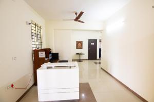 Habitación blanca con ventilador de techo y pasillo. en High Point Serviced Apartment, en Tiruchchirāppalli