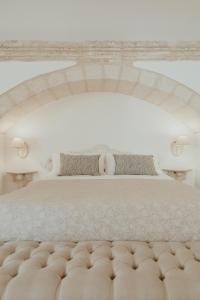 1 dormitorio con 1 cama grande con colcha blanca en Relais Il Mignano, en Nardò