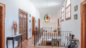 un atrio con pareti bianche e una scala con porta in vetro di Villa el Señorío Alameda by Ruralidays ad Antequera