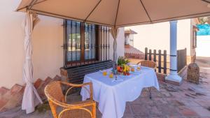 einen Tisch unter einem Sonnenschirm auf einer Terrasse in der Unterkunft Casa Rural la Higuera de Rios Antequera - La Higuera by Ruralidays in Antequera