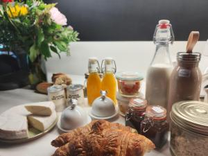 a table topped with cheese bread and bottles of milk at Chambre Trèfle in Entremont