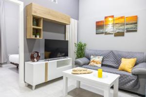 - un salon avec un canapé et une télévision dans l'établissement Apartamento Barrocal by Cadiz Time, à Cadix