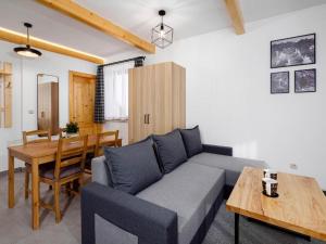 a living room with a couch and a table at Studio Apartment with Mountain View in Zakopane