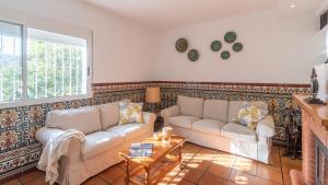 a living room with two couches and a table at Casa La Solea Cuevas Bajas by Ruralidays in Cuevas Bajas