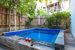 a swimming pool in a backyard with two glasses of wine at An Bang Beach - Salt Bungalow in An Bang