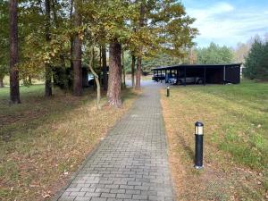 a brick path in a park with trees and a building at Ferienwohnung im Heidepark in Dessau