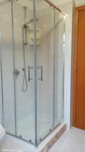 y baño con ducha y puerta de cristal. en Casa Maris en Torre Grande