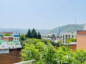 vistas a una ciudad con montañas en el fondo en Guest House Third Floor en Tiflis
