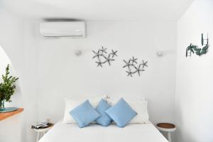 Rina Houses في كامبوس باروس: غرفة نوم بيضاء مع وسائد زرقاء على سرير