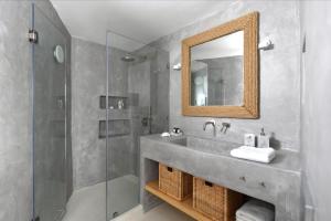 a bathroom with a sink and a mirror and a shower at Rina Houses in Kampos Paros