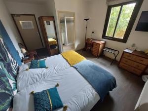 a bedroom with a large bed with blue and yellow pillows at Chez Terrassier - Logis Hôtels - Hotel et Restaurant in Vaissac