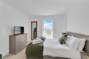 um quarto com uma cama, uma televisão e uma cómoda em 3 Bed- The Pavilion By Pureserviced em Plymouth