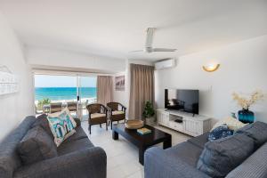 a living room with a couch and a tv at Frinton on Sea 2 in Ballito