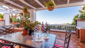 a table and chairs on a patio with a view at Villa Las Flores Frigiliana by Ruralidays in Frigiliana