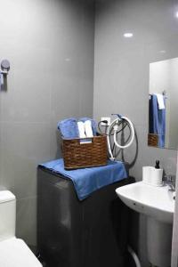 a bathroom with a sink and a basket of towels at Air Residences Makati - fully furnished condo with skyline views! in Manila