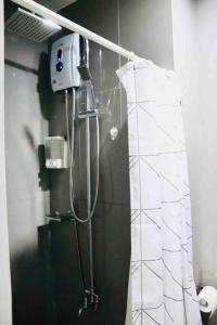 a shower in a bathroom with a shower curtain at Air Residences Makati - fully furnished condo with skyline views! in Manila