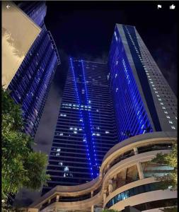 ein hohes Gebäude mit blauen Lichtern in der Nacht in der Unterkunft Air Residences Makati - fully furnished condo with skyline views! in Manila