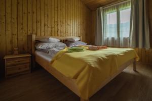 a bedroom with a bed with a yellow blanket on it at Biotour Camping & Restaurant in Ghimeş +72 photos