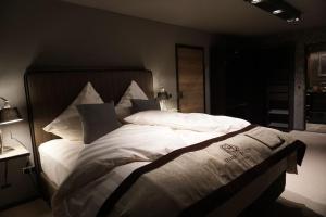 a bedroom with a large bed with white sheets and pillows at Chalet S - 5 Sterne Luxus Ferienhaus direkt am Eibsee und Zugspitze in Grainau