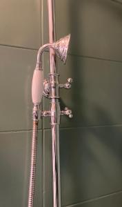 un soffione doccia in un bagno accanto a uno specchio di Les loges du théâtre Monsigny a Boulogne-sur-Mer
