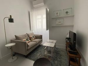 a living room with a couch and a television at CasaWolhão LIBERDADE maison de pêcheur avec toit-terrasse in Olhão