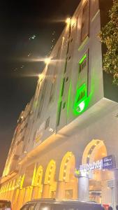 a building with a green sign on the side of it at Beat salsbil hotel in Al Madinah