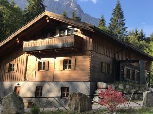 uma casa de madeira com uma varanda em cima em Chalet S - 5 Sterne Luxus Ferienhaus direkt am Eibsee und Zugspitze em Grainau