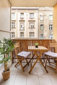 a table and chairs on a balcony with a building at APT Wit Free Secure Parking in Budapest