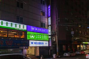a city street at night with signs on buildings at Hostel Mihojae Busan in Busan