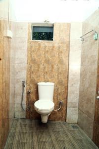 ein Bad mit einem WC und einer Dusche in der Unterkunft AWA Residency in Kochi