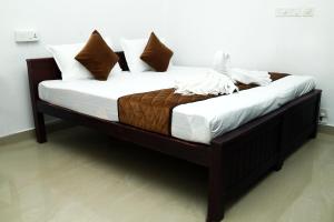 a bed with white sheets and pillows on it at AWA Residency in Cochin