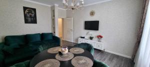 a living room with a green couch and a table at Apartamentai Klaipeda in Klaipėda