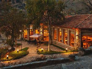 una casa con un tavolo e un ombrello davanti di Vardzia Resort a Vardzia