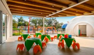 a playground with green and orange tables and a play structure at Camping Adria Mobile Homes Lanterna in Poreč