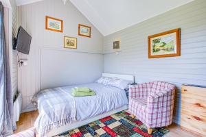 una piccola camera con letto e sedia di Cosy 1BR Snug in Upper Beeding a Upper Beeding