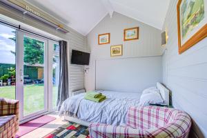 a bedroom with a bed and a tv and a window at Cosy 1BR Snug in Upper Beeding in Upper Beeding
