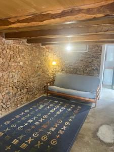 a bed in a room with a stone wall at EL PALLER in Riudarenes