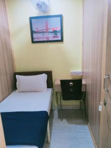 Kleines Zimmer mit einem Bett und einem Schreibtisch. in der Unterkunft Royal Cabin Stay in Mumbai