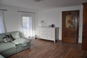 a living room with a couch and a dresser at Ferienwohnung, wenige Minuten vom Wörthersee in Schiefling am See