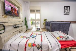 a living room with a bed and a couch at סוויטות לוגאסי - דירות אירוח נעימות עם מרפסת פרטית מול הנוף in Sheʼar Yashuv