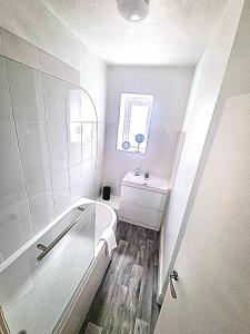巴克斯頓的住宿－Torr Mews，白色的浴室设有水槽和淋浴。
