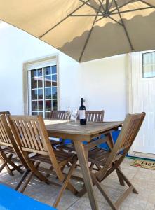 a wooden table with two chairs and a bottle of wine at Serra mar in Cruz de João Mendes