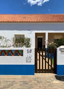 a white and blue house with a wooden fence at Serra mar in Cruz de João Mendes