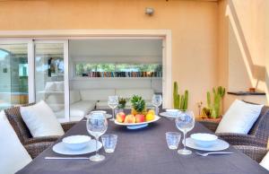 einen Tisch mit einer Schale Obst und Weingläsern in der Unterkunft Penthouse Marina-Seaview Jacuzzi and Terrace in Rapallo
